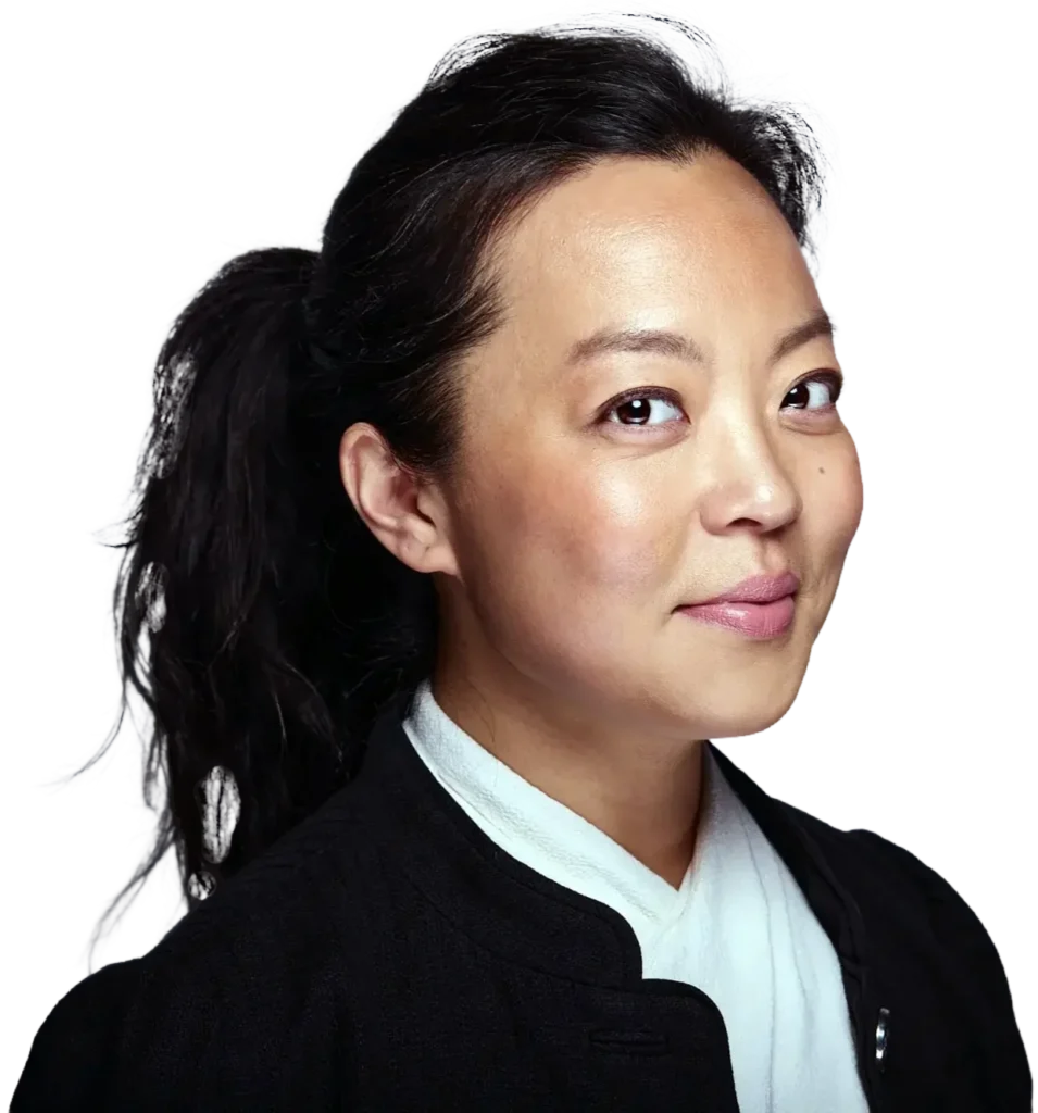 Fran Hong with her hair pulled back, wearing a black jacket over a white top, smiles while looking slightly to the side.